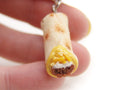 Miniature tortilla with filling held between fingers on a white background