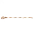 A rose gold-colored Swarovski chain extender lying on a plain background.
