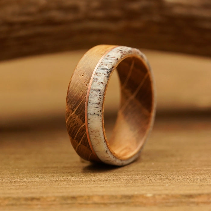 The Faroe, a handcrafted wooden ring featuring a striking white inlay, stands upright on a wooden surface, highlighting its natural grain and smooth finish—a stunning example of artisan craftsmanship that's sure to impress.
